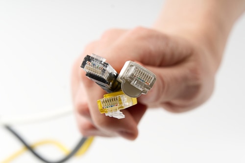 person holding 3 types of ethernet cable